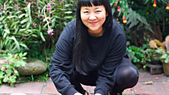 Fotografía en primer plano de la artista Nobara Hayakawa en cuclillas y sonriendo
