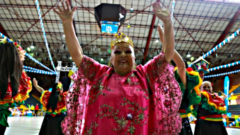 Fotografía en primer plano de una señora de la tercera edad bailando y con rostro feliz
