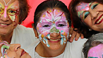 Fotografía en primer plano de los rostros pintados de tres señoras de la tercera edad