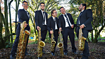 Fotografía de los cinco saxofonistas de cámara en un parque sonriendo