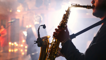 Foto en primer plano de un músico interprete de saxofón en acción.