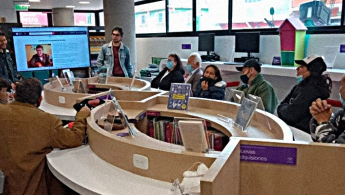 Fotografía de un grupo de adultos mayores en un espacio de taller en la biblioteca pública