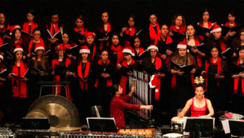 Foto en la cual aparecen muchos cantantes del coro con gorros de navidad