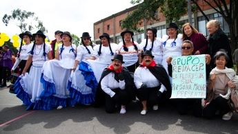 Personas mayores posando para la foto, con sus trajes típicos