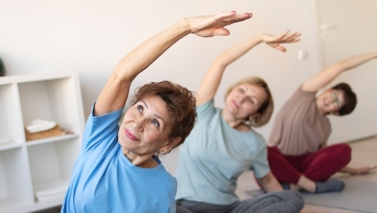 Tres adultas mayores realizando ejercicios de estiramiento