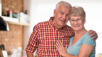 Dos adultos mayores (Mujer y Hombre) sonriendo 