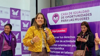 Tres mujeres hablando sobre un fodo de un programa de la Secretaría de la Mujer