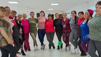 Adultas mayores y jóvenes posando para la foto, todas sonriendo
