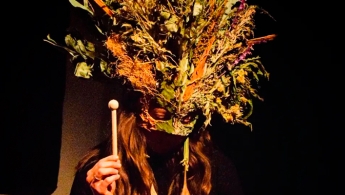 Persona de cabello largo con una máscara de plantas secas