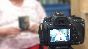 Señora de la tercera edad frente a una cámara grabando un testimonio.