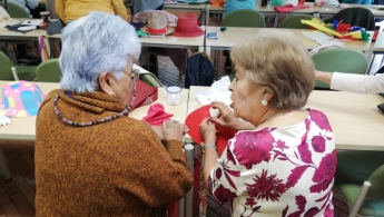 Dos adultas mayores conversando y participando del espacio de taller