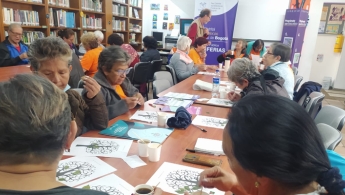 Adultos mayores en espacio de taller en la biblioteca
