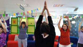 Adultas mayores realizando yoga en la biblioteca