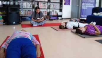 Mujeres en la biblioteca haciendo yoga.