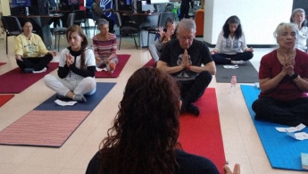 Personas mayores haciendo yoga en la biblioteca