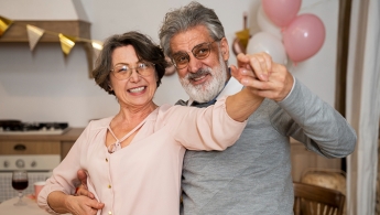 Pareja de personas mayores bailando y sonriendo