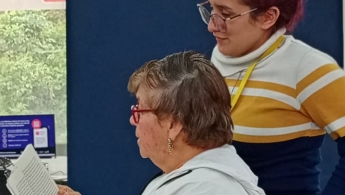 Dos mujeres, una de ellas persona mayor leyendo