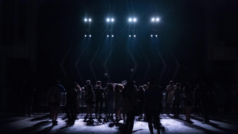 Personas ubicadas en tarima de teatro