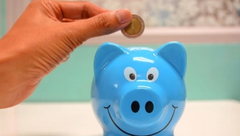Mano con moneda ahorrar alcancia