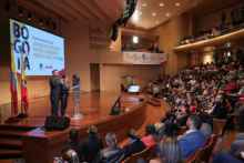 Hombre y mujer en una tarima, hablando al público