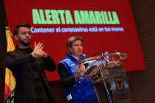 Hombre haciendo lenguaje de señas y mujer hablando y mirando hacia el frente