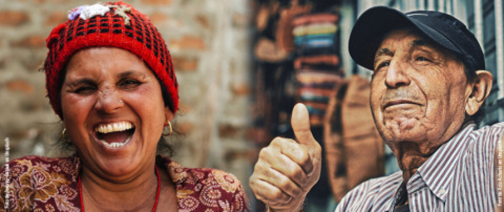 Una mujer al lado izquierdo riendo y mirando al frente y un hombre al lado derecho levantando el dedo gordo de su mano, indicando que todo bien.