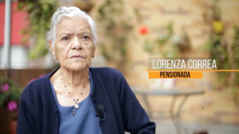 Mujer de la tercedad edad, sentada, mirando al frente.