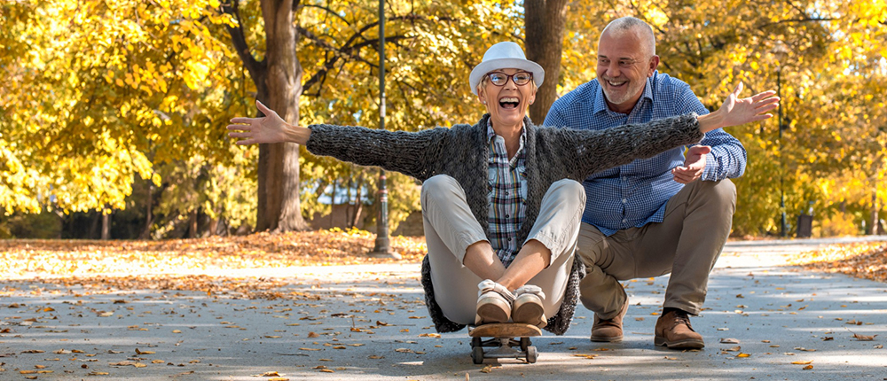 Fotografía de una pareja de la tercera edad jugando felices como niños.